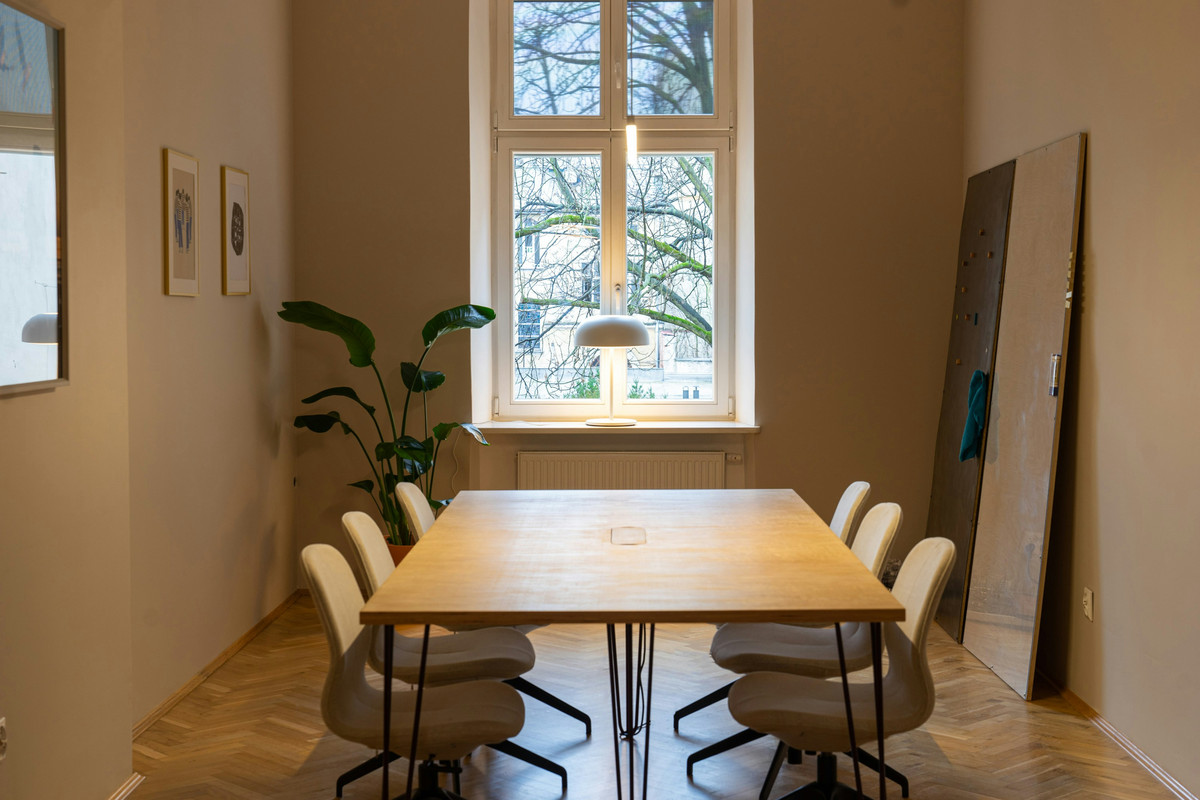 A small meeting room with a timber table and chairs by a window